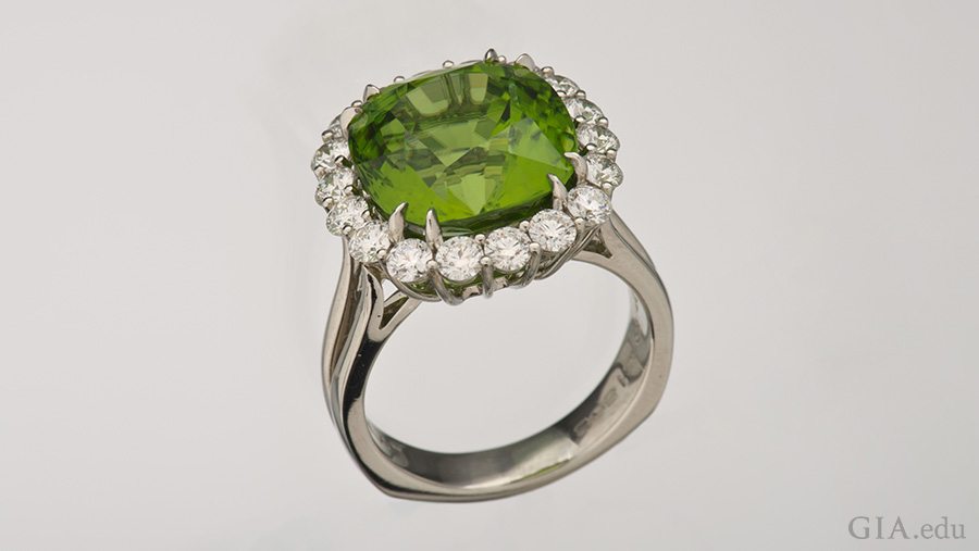 The 10.89 carat peridot in this platinum ring is surrounded by a halo of diamonds, showing off the August birthstone.