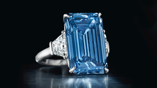 The 14.62 ct. emerald cut Fancy Vivid Blue Oppenheimer diamond is flanked by diamonds in a ring setting.. Christie’s sold the 14.62 ct. Fancy Vivid blue Oppenheimer Blue diamond – the largest Fancy Vivid blue ever to come up for sale – for $57.5 million on May 18. Courtesy of Christie’s. 这颗镶嵌在戒指中的 14.62 克拉 祖母绿式切工艳彩蓝色奥本海默钻石两侧镶嵌着钻石。