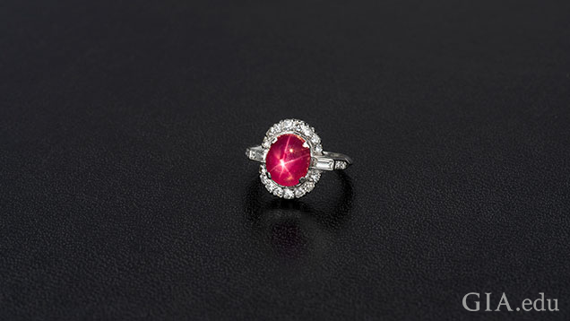 Oval ruby cabochon framed with diamonds. Oval ruby cabochon framed with diamonds.