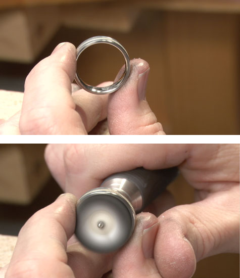 Jeweler holding a platinum band at the bench, in preparation for buffing